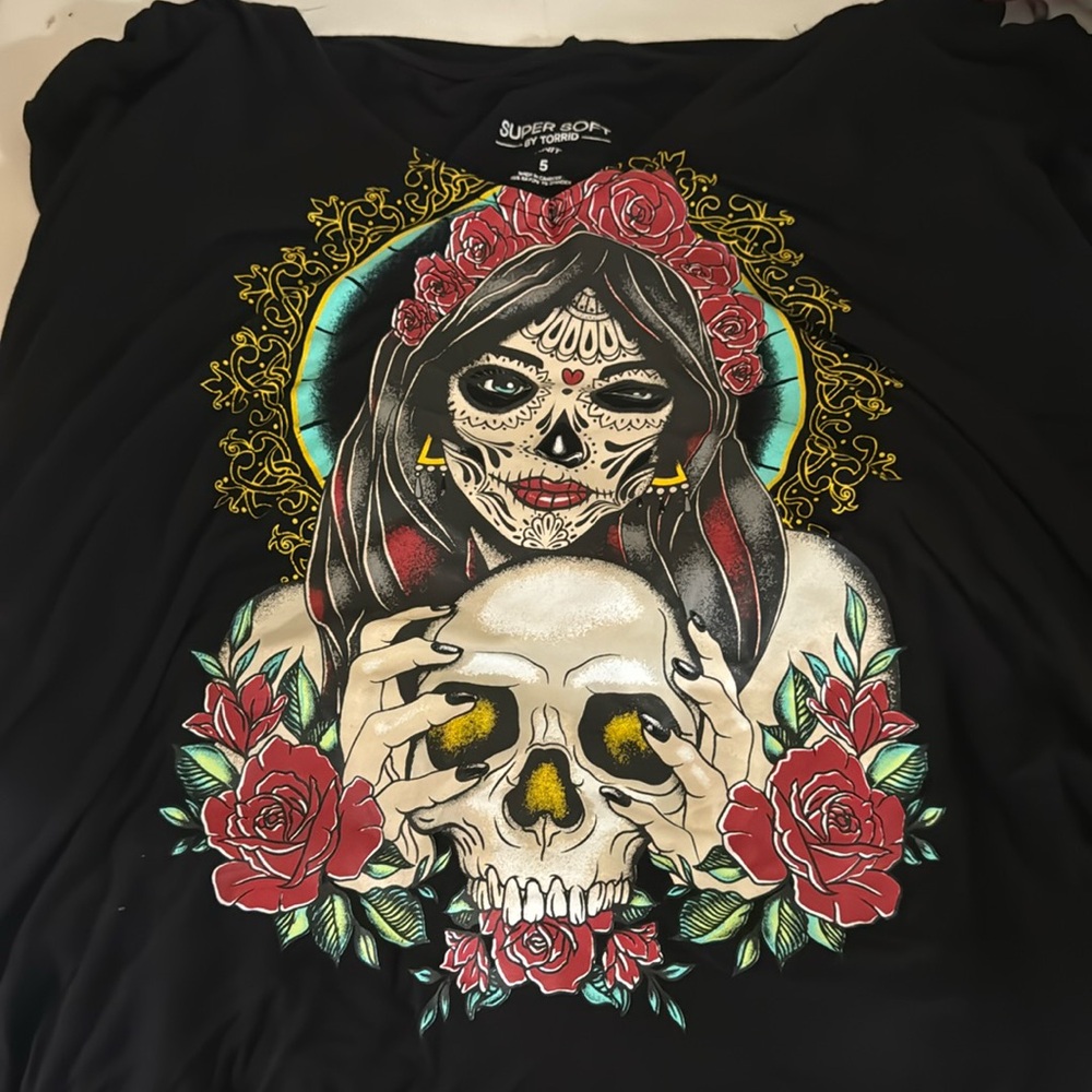 Hooded long sleeve hi-lo hem tee shirt with día de los muertos inspired print.